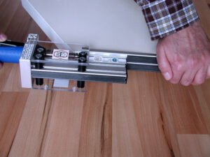 Beim Bündigfräser für Holz-Möbelteile wird das fräsende Werkzeug im Gegenlauf geführt. An einer rechten Ecke wie im Bild dargestellt erfolgt die Bewegung von unten nach oben. Der stirnseitige Kantenüberstand wird abgefräst.